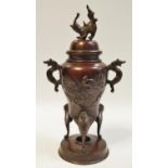 A Meiji period patinated bronze twin handled urn and cover decorated with exotic birds on prunus c.