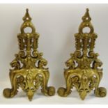 A pair of ornate French brass fire dog fronts