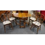 An oak dropleaf table and four wheelback dining chairs.