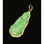 A 14ct gold and carved jade Buddhistic tablet pendant, marked 585, 3.5cm, 3.