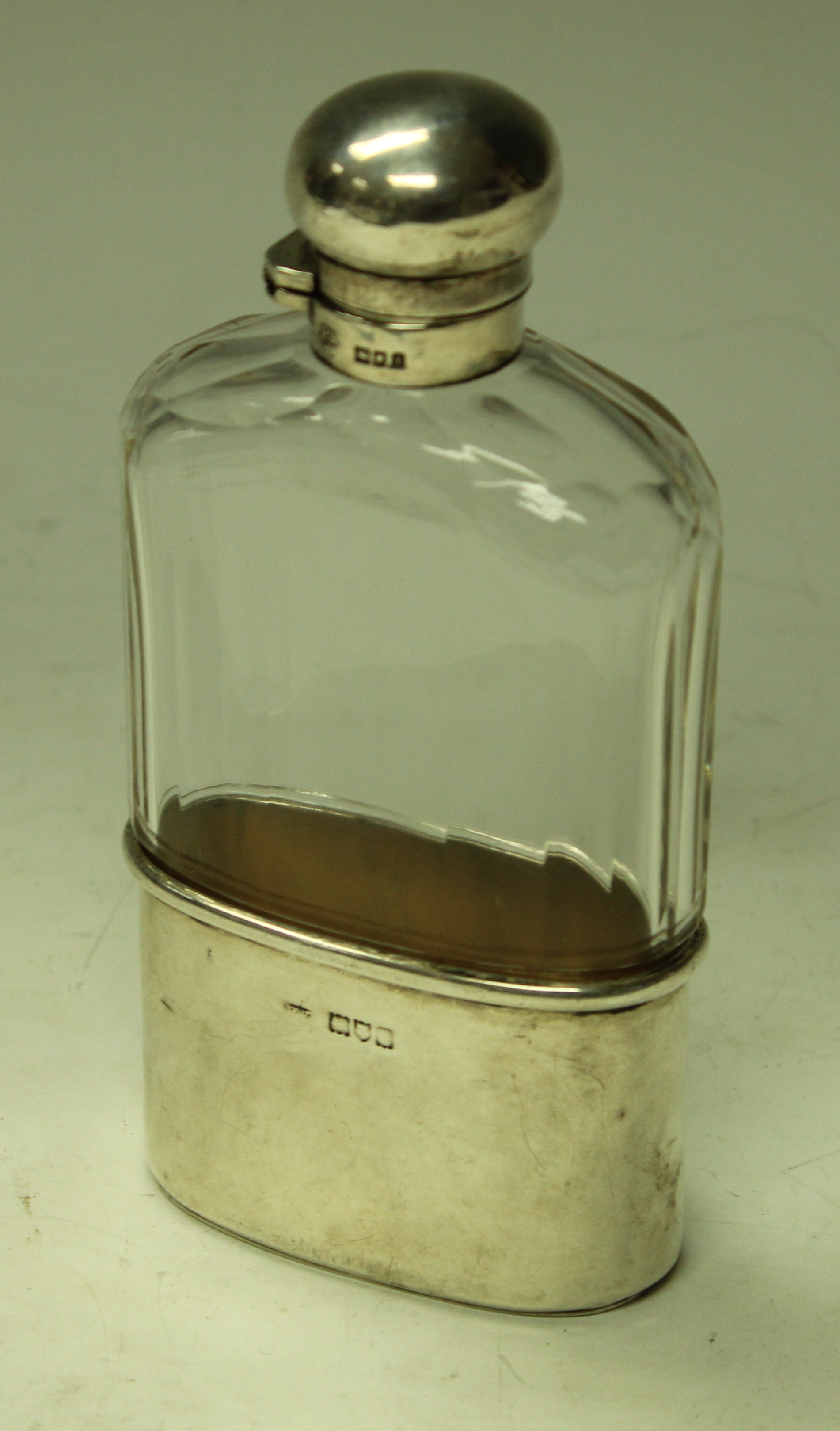 An Edwardian silver and clear glass hip flask,