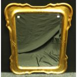 A contemporary giltwood shaped rectangular looking glass,