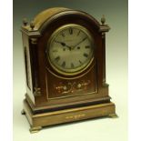 An early 20th century mahogany mantel clock, the silvered dial with Roman numerals,