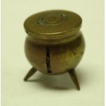 A 19th century novelty seamstress tape measure in the form of a lidded cauldron