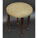 A Middle Eastern/North African tray top occasional table, embossed with traditional motifs,