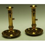 A pair of 18th century bell metal ejector table candlesticks with spool shaped sconces and dished