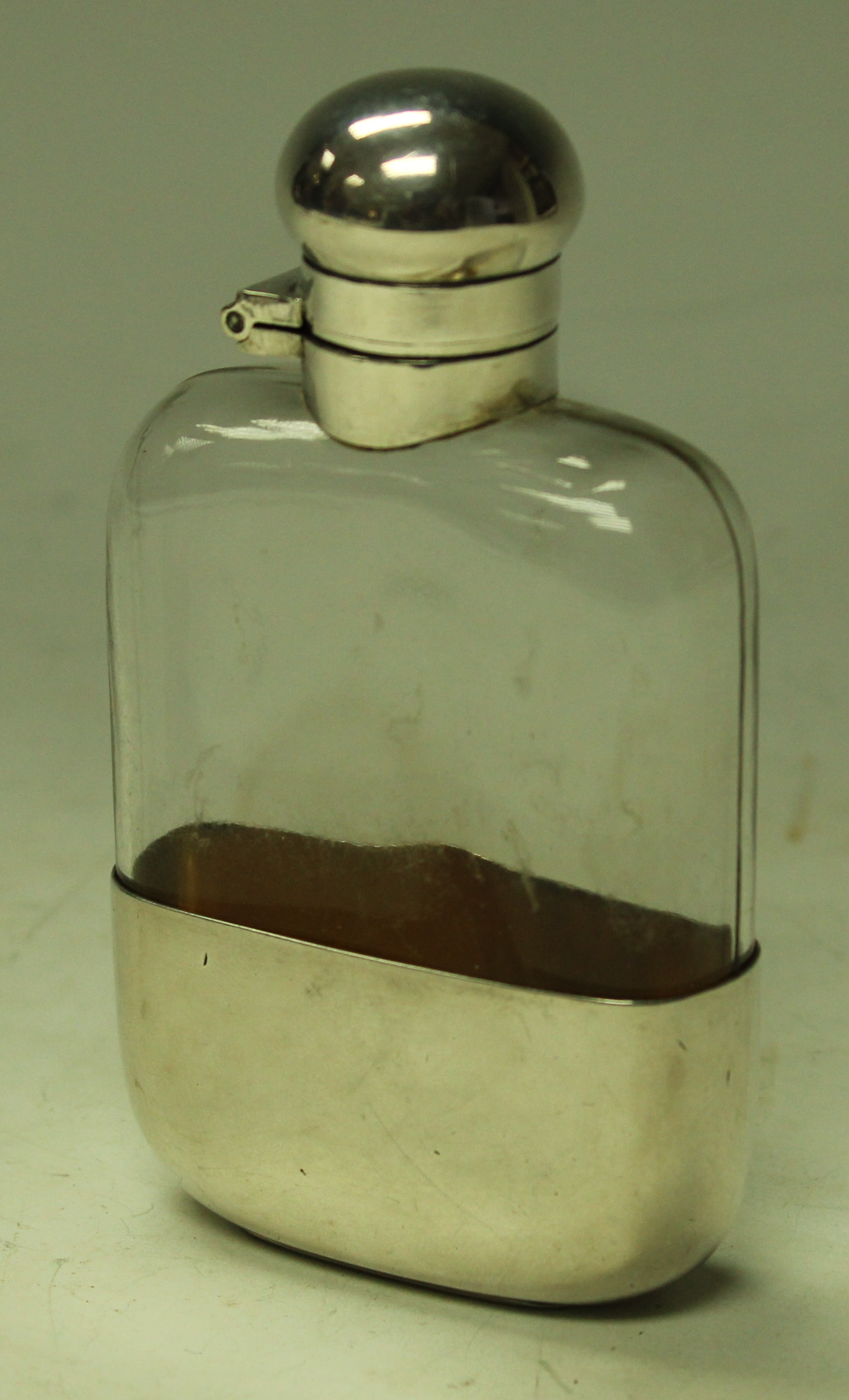 A silver coloured metal and clear glass flask, twist-cap cover,