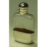 A silver coloured metal and clear glass flask, twist-cap cover,