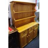 A pine dresser, shaped uprights and two shelves to top,