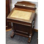 A late Victorian mahogany Davenport desk hinged top enclosing a segmented interior,
