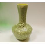 A Bretby celadon style globular vase decorative with fanciful dragons, a large green glass goblet,