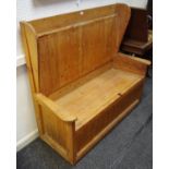 A pine settle, high wing back, hinged seat enclosing storage, 121.5cm high x 12cm wide x 54.