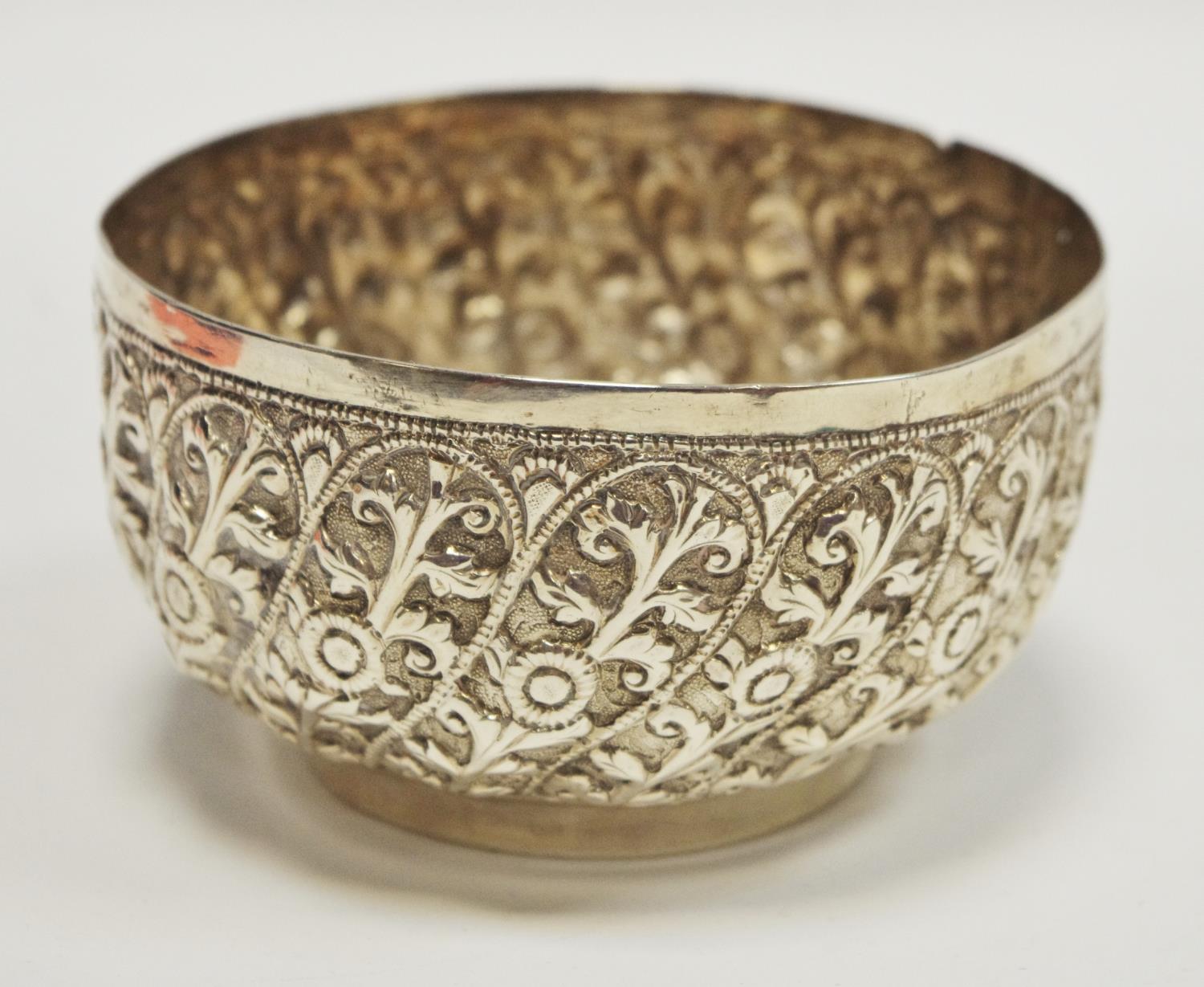 A white metal Indian bowl repoussé decoration of foliate scrolled panels 79g gross
