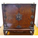 A Chinese style two door cabinet, resting on scroll feet, 53cm high,