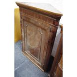 A George III splay fronted oak corner cabinet,