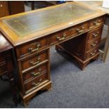 A Regency style twin pedestal knee hole desk, tooled green leather inlaid writing surface,