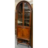 A mahogany dome top corner cupboard, arched glazed doors over panel door cupboard, turned legs,