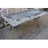 A reconstituted stone, tile and wrought iron verandah table.