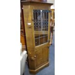 A Nigel Griffiths oak floor standing corner cupboard, lead glazed door to top,