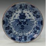 An 18th century Dutch Delft circular Peacock dish, typically painted in underglaze blue, iron red