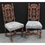 A pair of early 20th century oak side chairs, carved throughout with scrolling acanthus, stuffed
