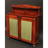 A George IV gilt metal mounted rosewood library pier cabinet, pointed arched superstructure, with