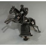 A 20th century chrome plated car mascot, of a jockey taking a steeple fence, 14cm high