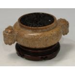 A Chinese brown soapstone ding censer, the sides carved in relief with a ferocious dragon, the