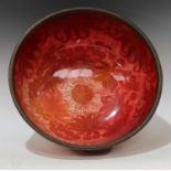 A Bernard Moore red lustre punch bowl, decorated with large leaves on a red ground, metal rim,