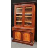 A Victorian mahogany library bookcase, outswept cornice above a pair of glazed doors enclosing