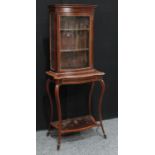 An Edwardian satinwood crossbanded mahogany serpentine display cabinet, outswept cornice above a