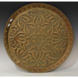 An Art Nouveau/Arts & Crafts circular brass tray, embossed with scrolling foliage and studs, approx.