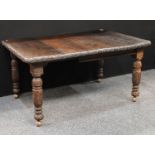 A late Victorian oak extending dining table, rounded rectangular top with carved edge, boldly turned