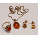 A 9ct gold and amber suite of jewellery, comprising ring, pendant and chain, and a pair of earrings,