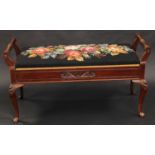 A late Victorian/Edwardian walnut duet stool, hinged cover with floral woolwork stuffed over