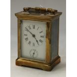 A brass carriage clock, five glass panels, white enamel dial, Roman numerals, subsidiary seconds