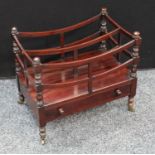 A George IV mahogany Canterbury, bowed divisions, turned supports, drawer to base, brass casters,