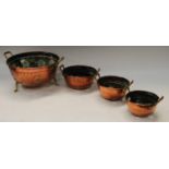 A set of four pierced copper and brass graduated collanders, the largest 31cm wide overall