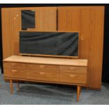 A mid 20th century teak effect bedroom suite, comprising two double wardrobes and a dressing