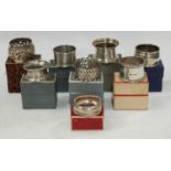 A collection of eight silver napkin rings, all boxed