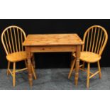 A pine kitchen table and two chairs.