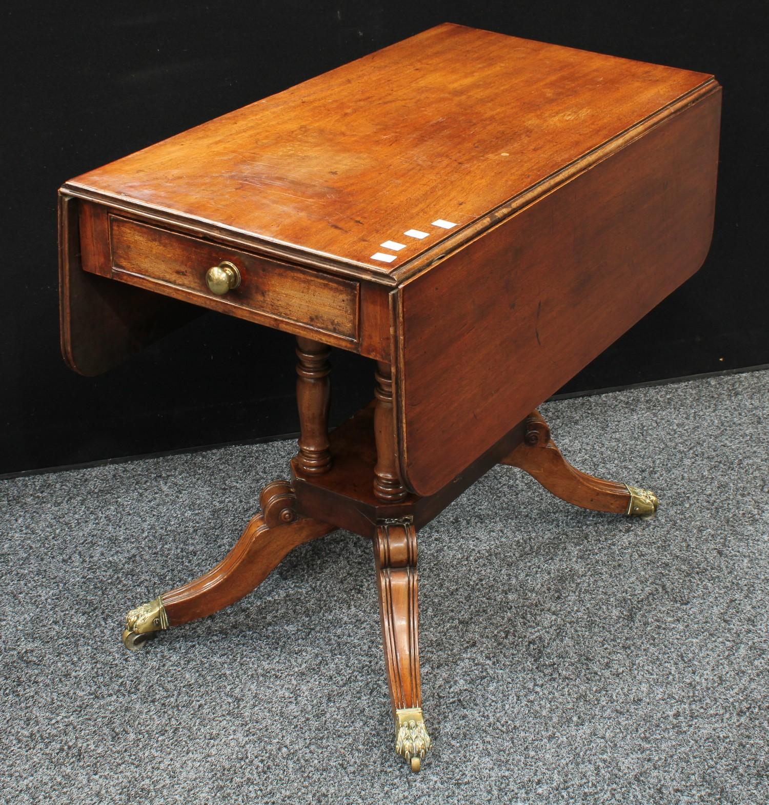 A Regency mahogany Pembroke table, rounded rectangular top with fall leaves, above a single frieze