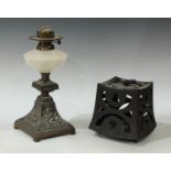 A Victorian Aesthetic movement cast iron and milt glass paraffin oil lamp, the base cast with lion
