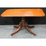 A Regency mahogany rectangular breakfast table, tilting top, turned column, sabre legs terminating