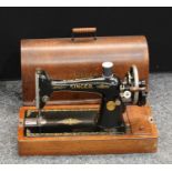 A manual Singer sewing machine, arched oak carry case with key