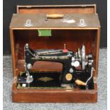 A Singer sewing machine, manual and fitted to use with electricity, carry case