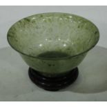 A Chinese green jade flared circular bowl, quite plain, 12.5cm diam, hardwood stand