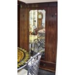 An Edwardian mahogany double wardrobe, bevel edged mirror to central door, deep drawer to base.