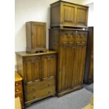 A Jacobean style bedroom suite comprising gentleman's wardrobe with linenfold paneling, tallboy,