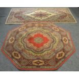 An octagonal throw rug in hues of cobalt green an cream on a red ground. 139cm x 139cm; a Wilton
